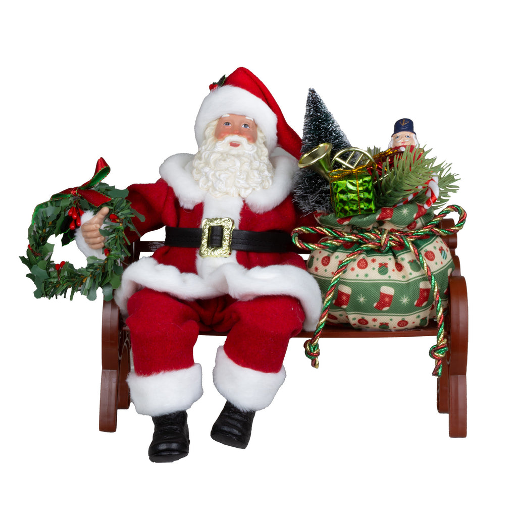 Weihnachtsmann Figur auf Bank mit Geschenksack & Kranz 28 cm