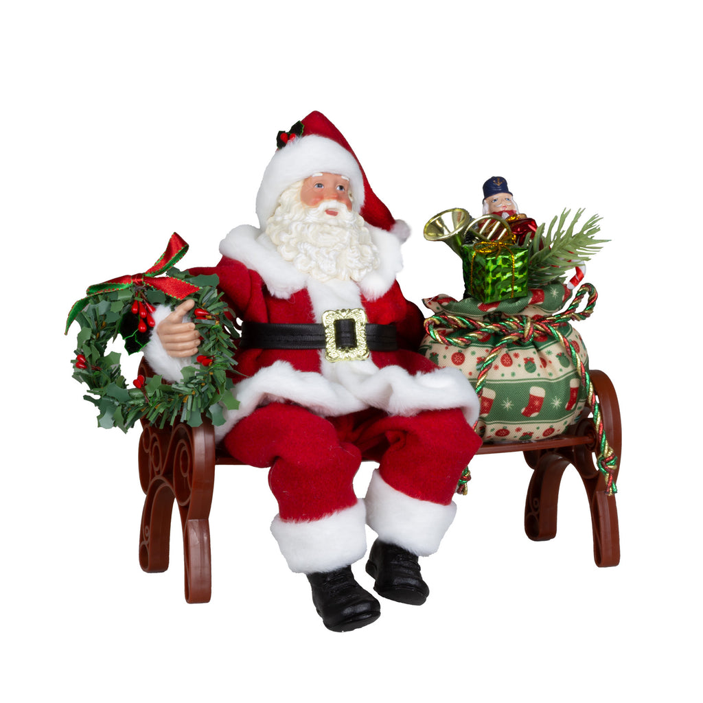 Weihnachtsmann Figur auf Bank mit Geschenksack & Kranz 28 cm
